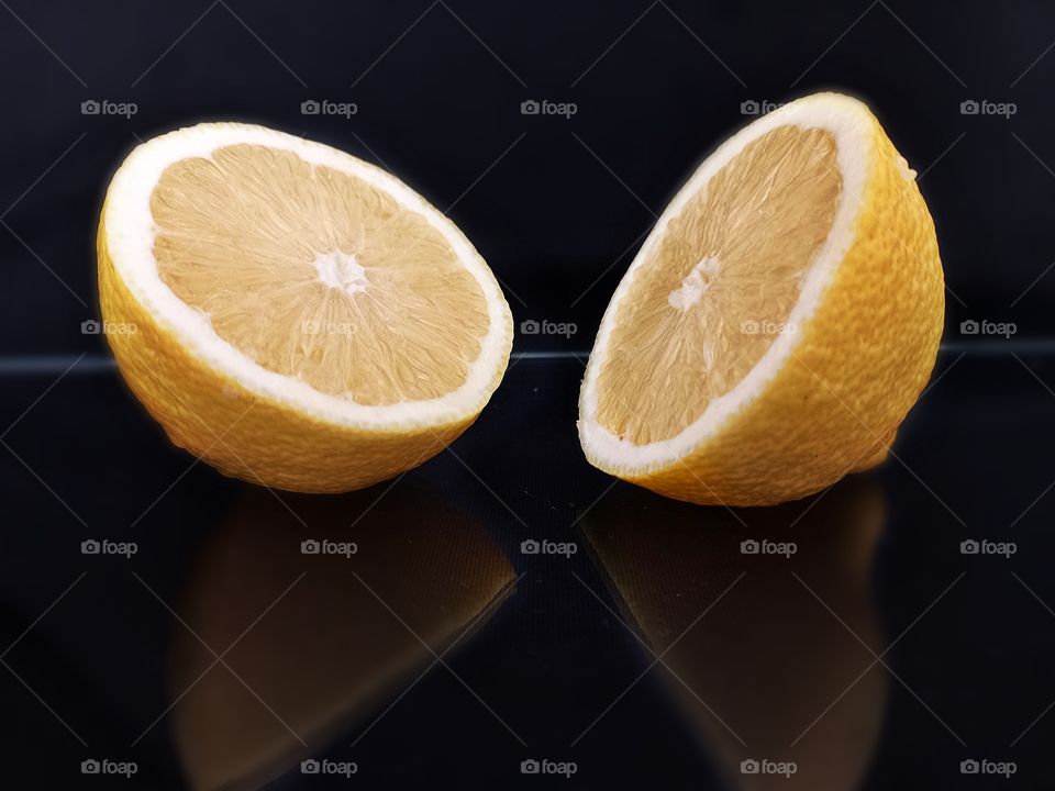 reflection on black glass of lemon slices