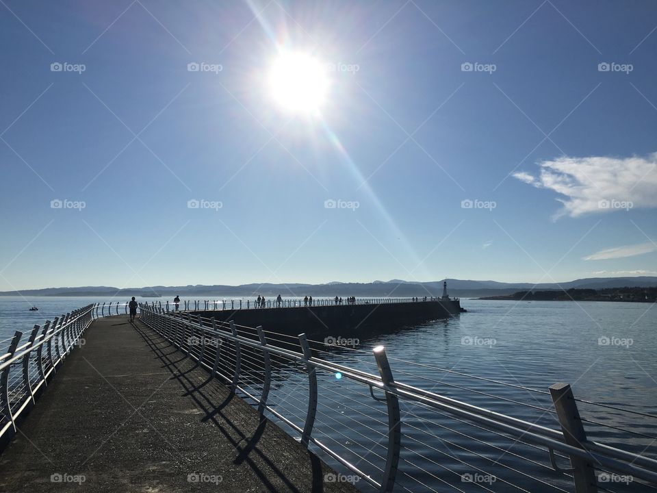 Sun ray over the sunny breakwater