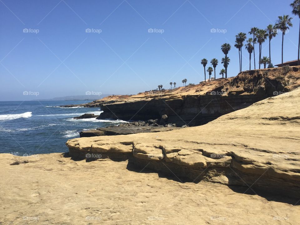 Sandy cliff overlooking a bright blue ocean on a clear, sunny day in San Diego, California