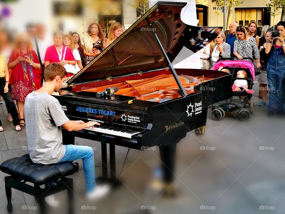 Young man playing piano on street