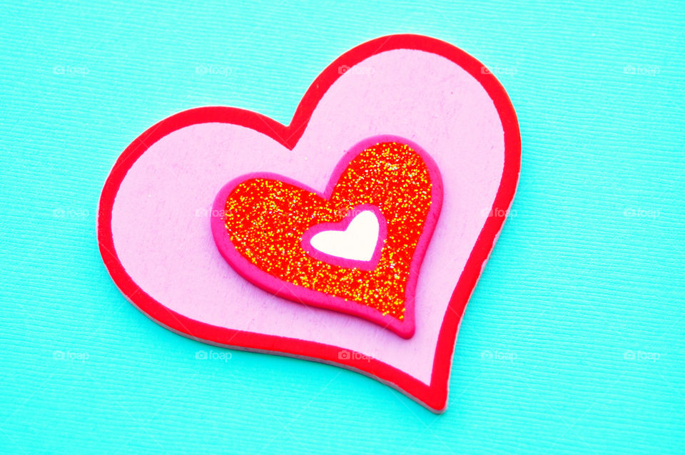 valentine's Day concept. Pink  heart against a turquoise background.
