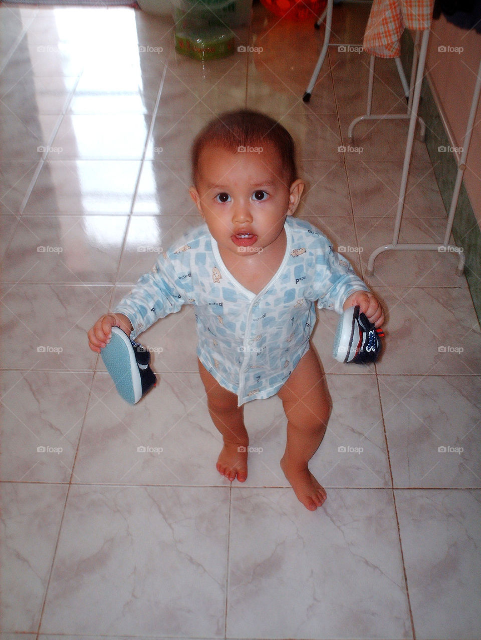 boy walking with shoes on hand 