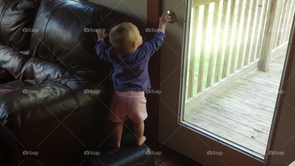 Toddler using stool to try to unlock door