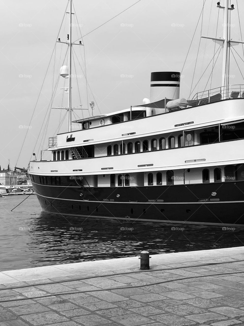 Black and white photo of an old classic small cruise liner docked in Dubrovnik, Croatia.