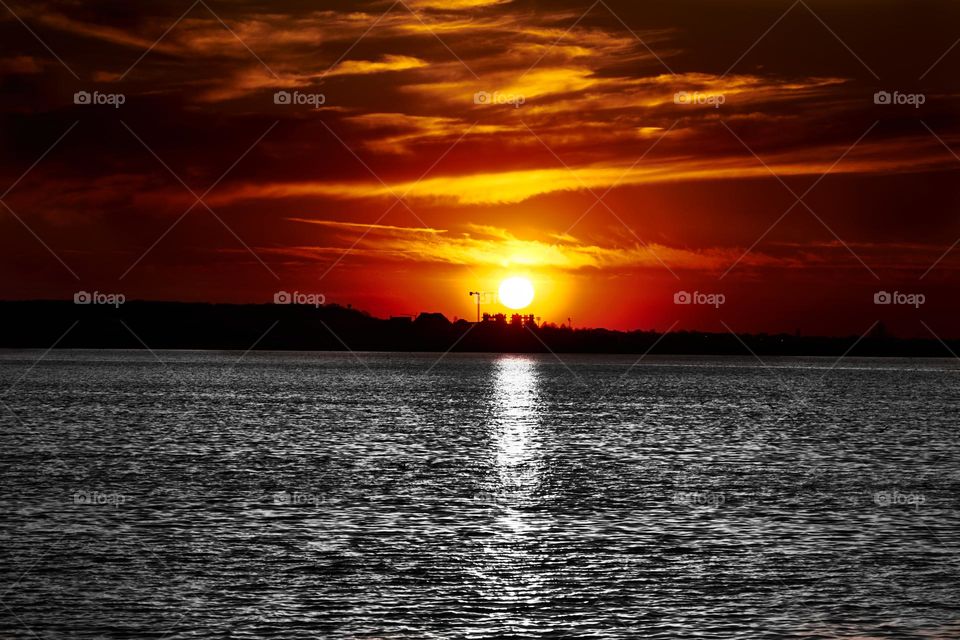 At sunset, on the horizon you can see the cranes that build the city.
