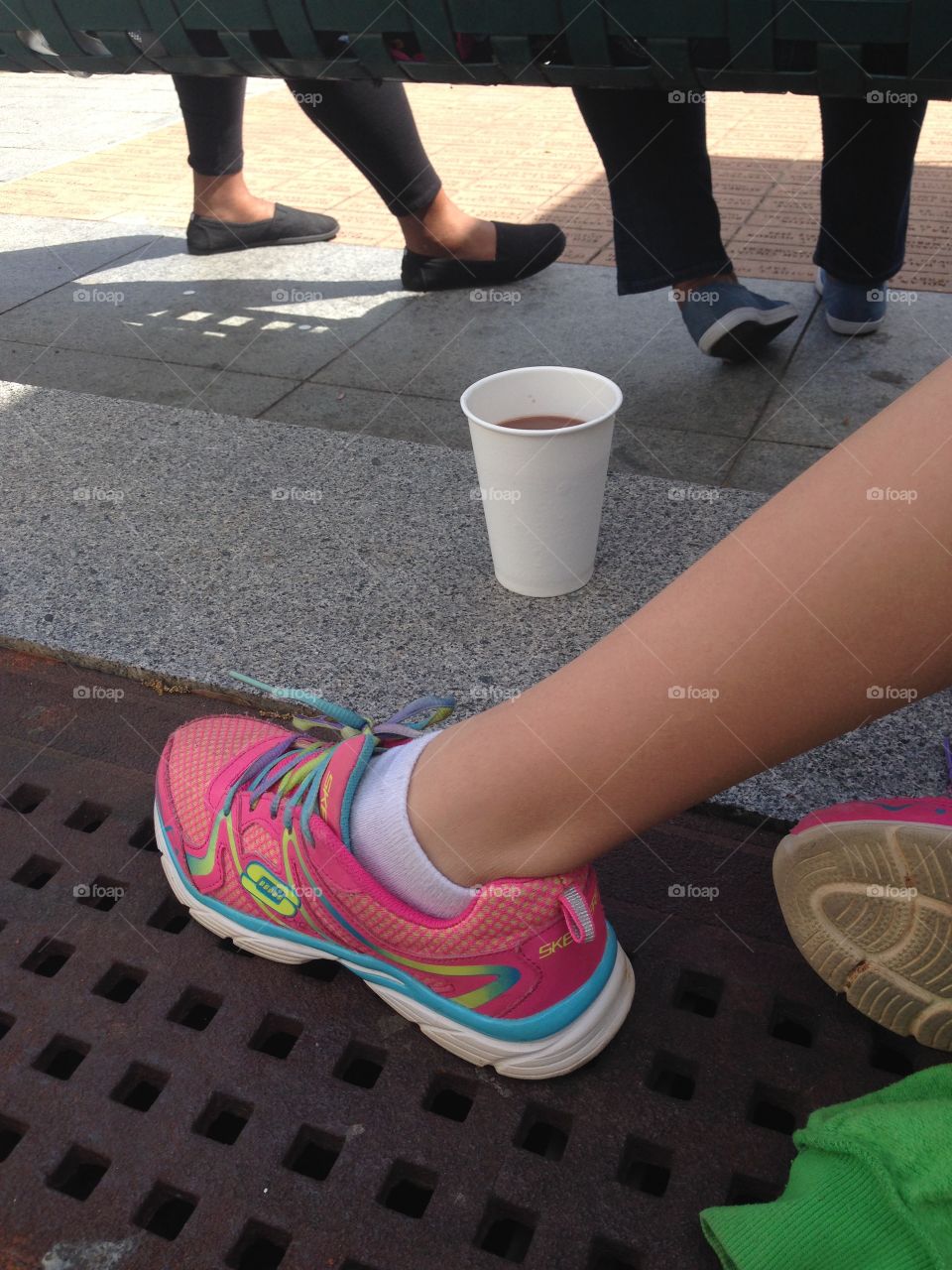 Sidewalk, feet of people sitting