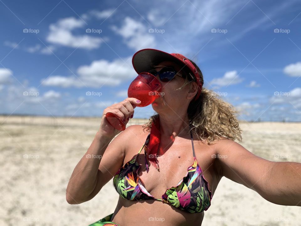 Woman drinking wine on the beach