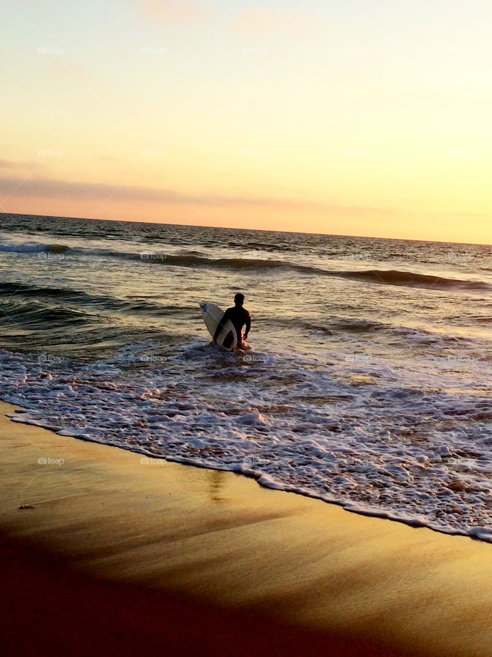 Winter Sunset . Surfer watching the waves and the sunset in Hermosa Beach, California 