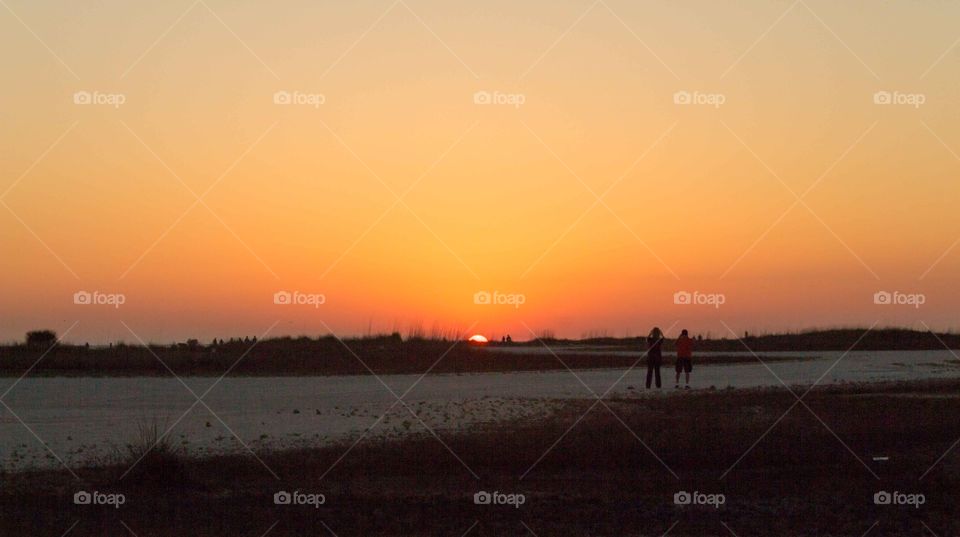 Florida. Couples watching sun set at the beach. 