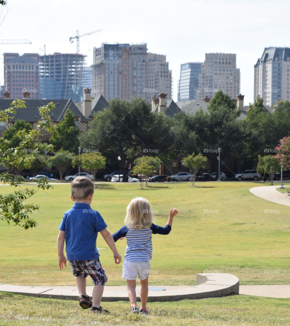 Toddlers at city park. Twins having fun in the city