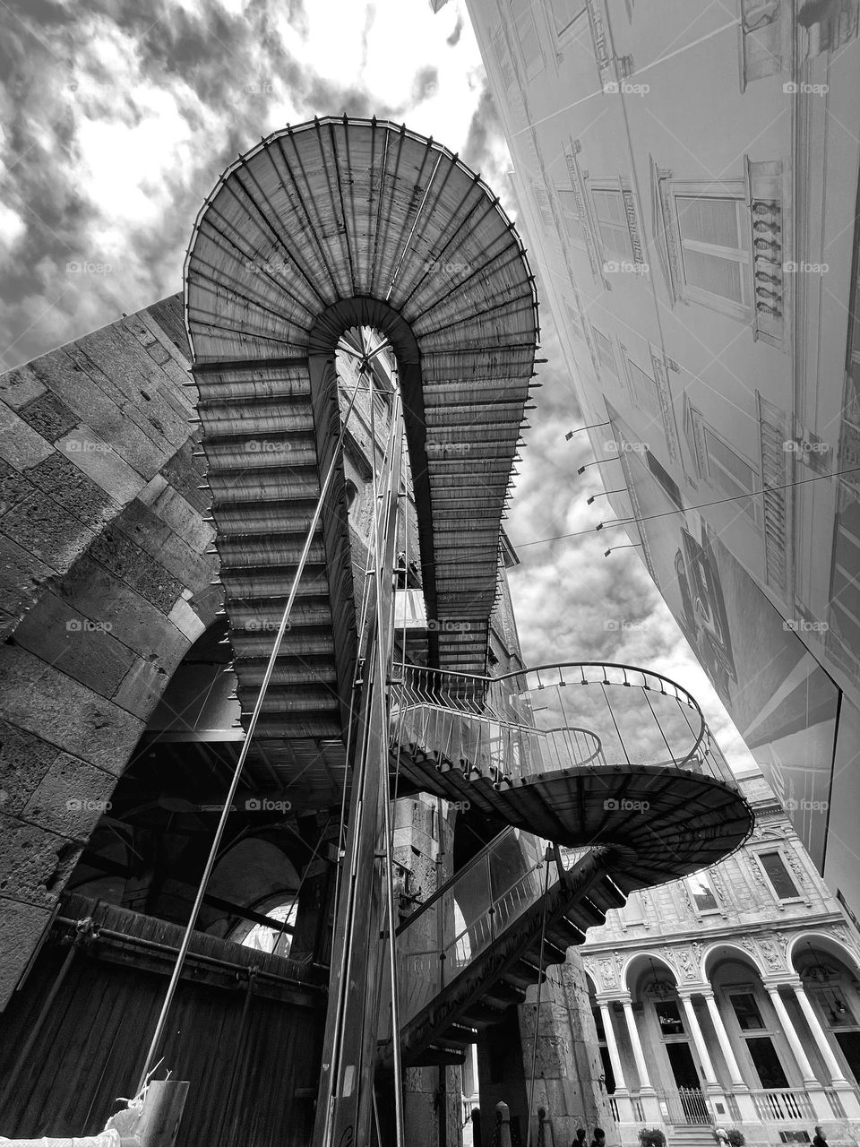 emergency stairs of an old building in the city center under a cloudy sky, monochrome shot