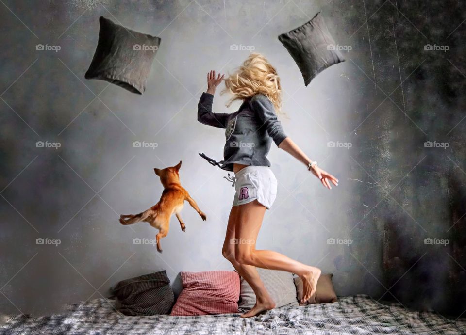 woman jumping on bed with dog