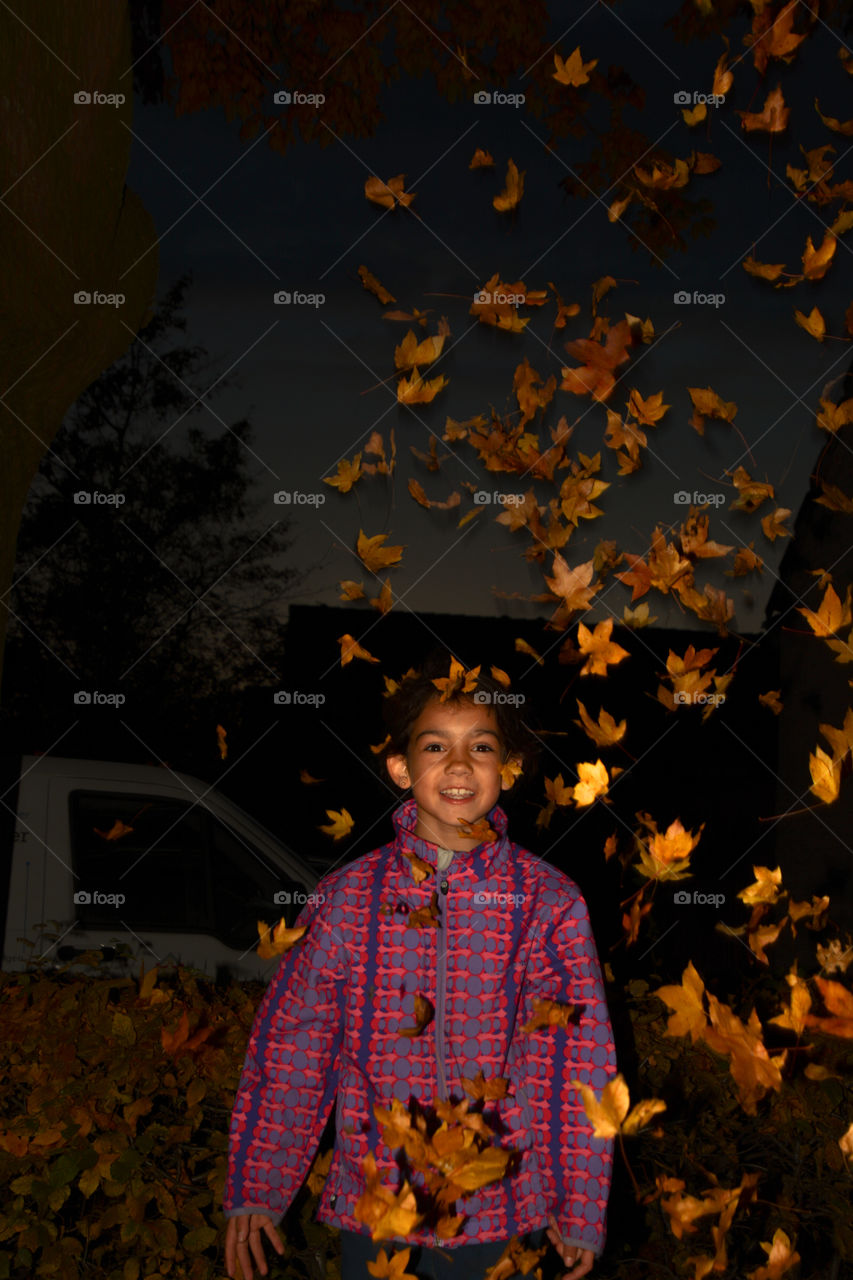 Little girl throwing leafs up in the air