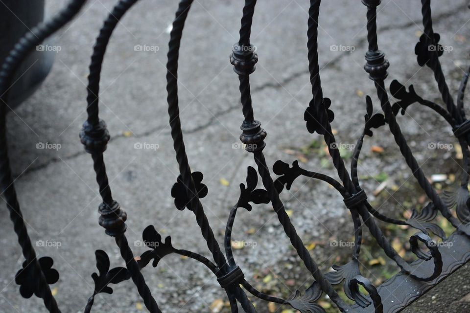 Old black cast iron wrought iron fence with floral ornaments
