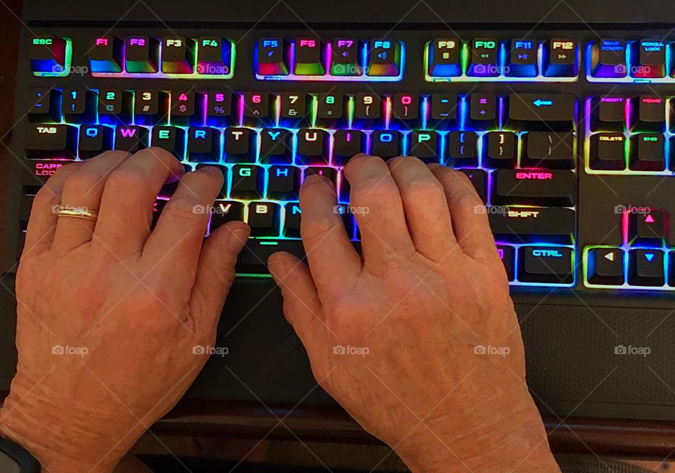 Typing on a brightly illuminated colored keyboard .