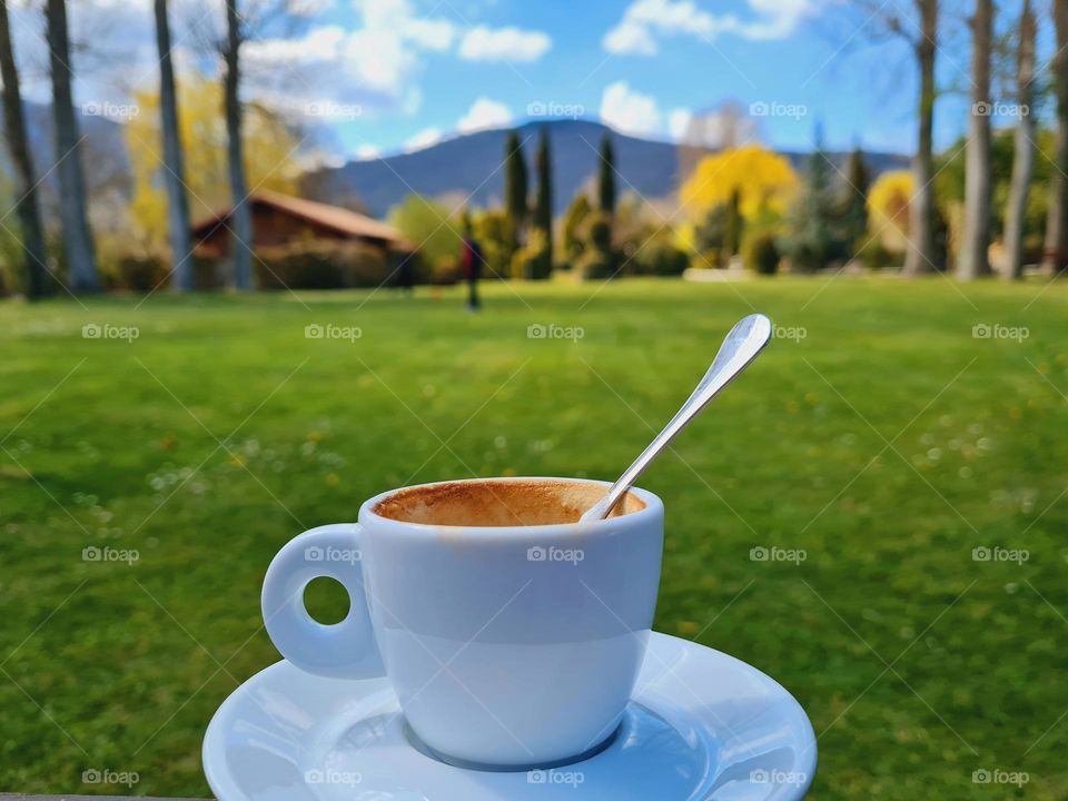 cup of espresso coffee in the foreground and mountain in the background