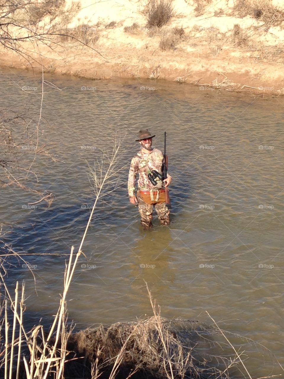 duck hunter in Oklahoma wading in creek