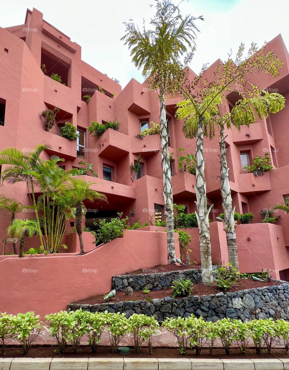 Geometric red building loaded with plants