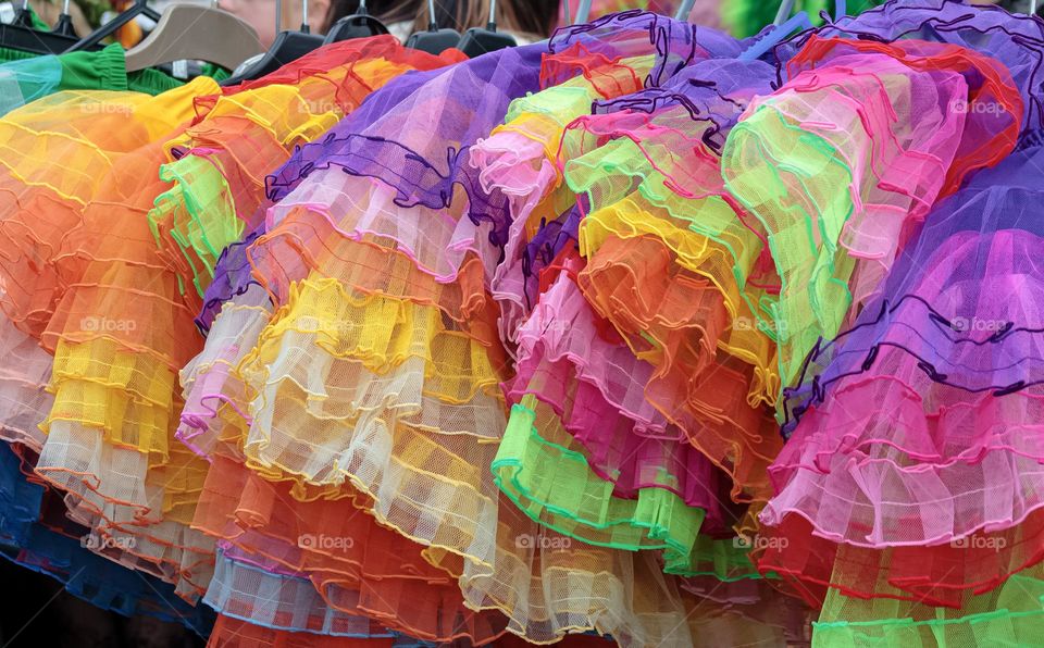 A row of colourful netted skirts on hangers