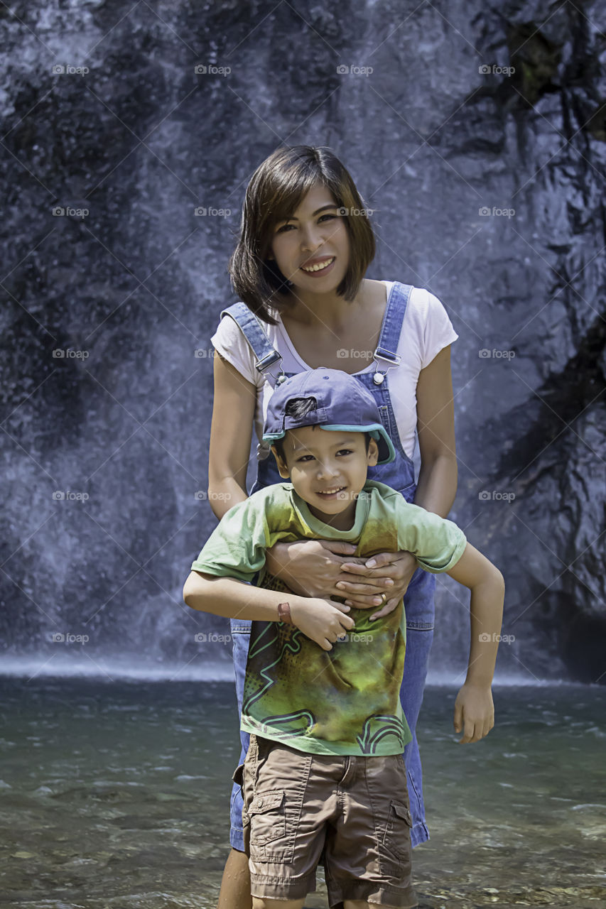 Mother and son were playing water at Chok Kra-Din WaterFalls at Kanchanaburi in Thailand