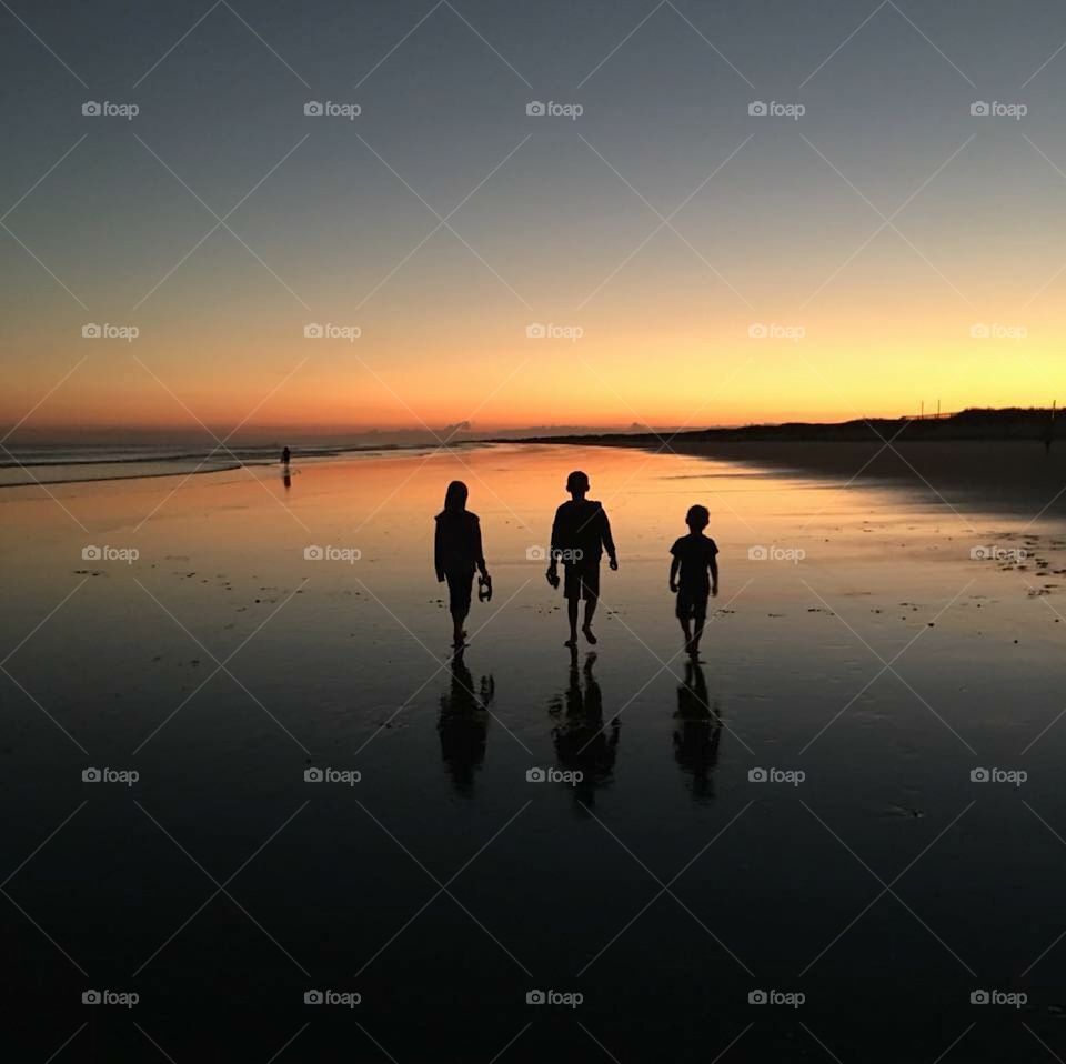 Children Walking on Beach At Sundown  