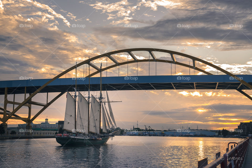 Sailboat under Hoan Bridge in Milwaukee, WI at sunset