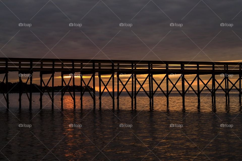 Sunrise view of a pier stretching out into the Neuse River estuary at Camp Seagull in North Carolina. 