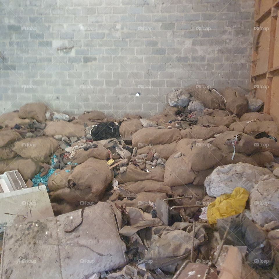 Filled bags with shoes. in abandoned barn.