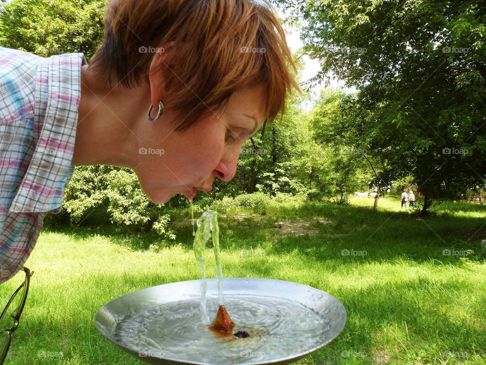 The girl is drinking water on a hot summer day