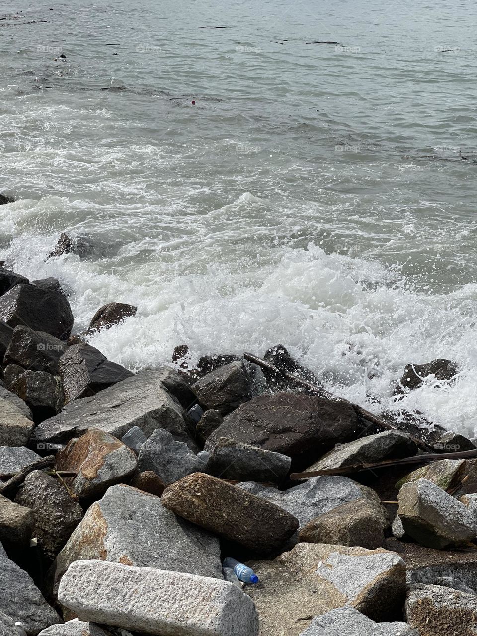 Wave crashing on the rocks by the shoreline 