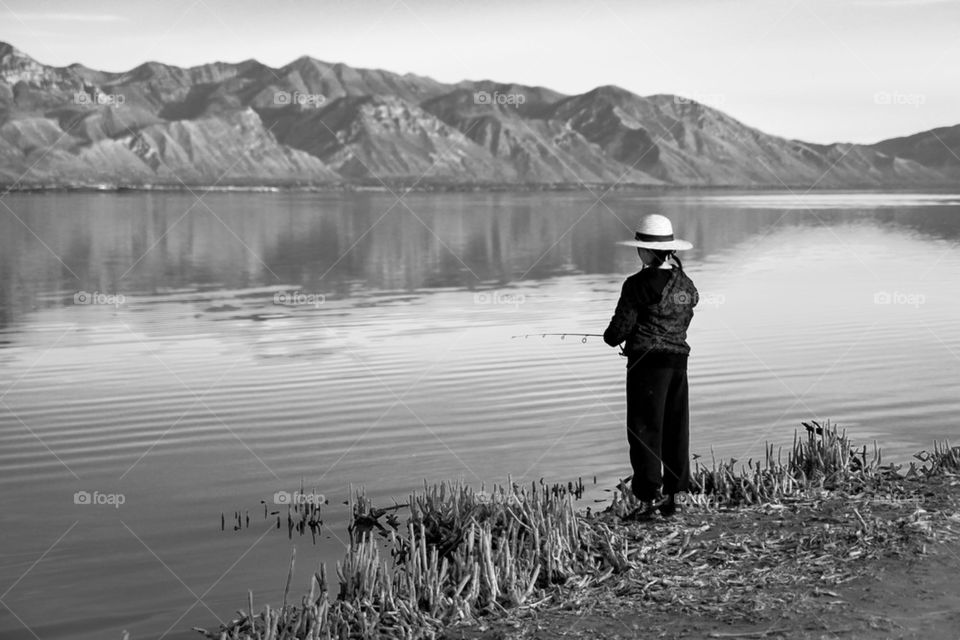 Fisherman standing near lake