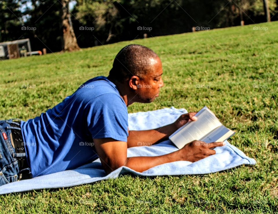 Man reading book in park