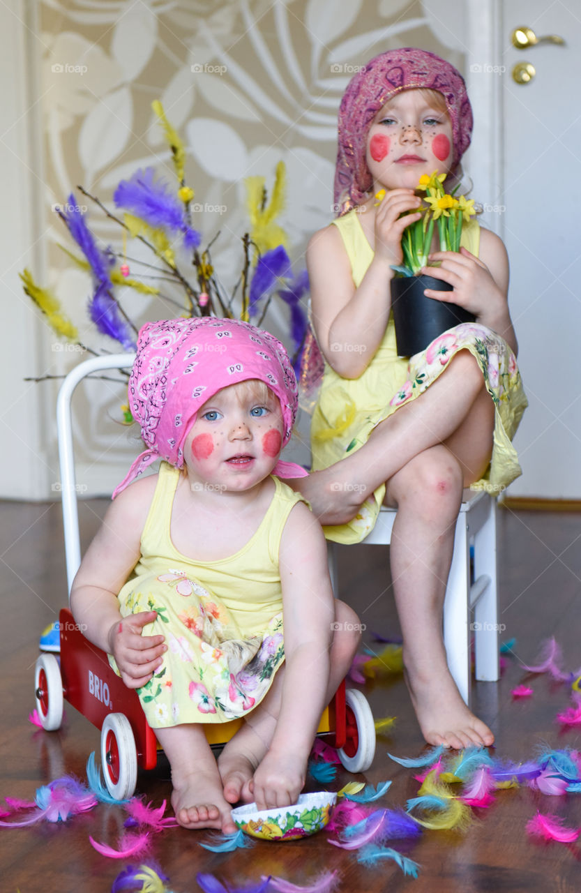 Two young sisters having fun infront of the camera with easter theme.