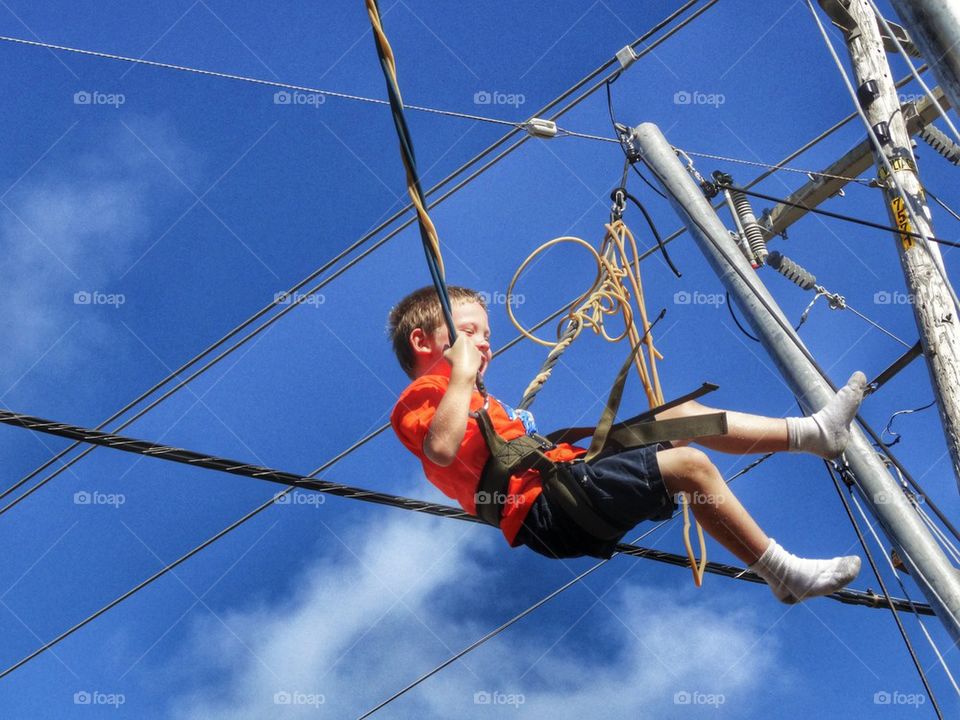 Acrobat Swinging On Wires