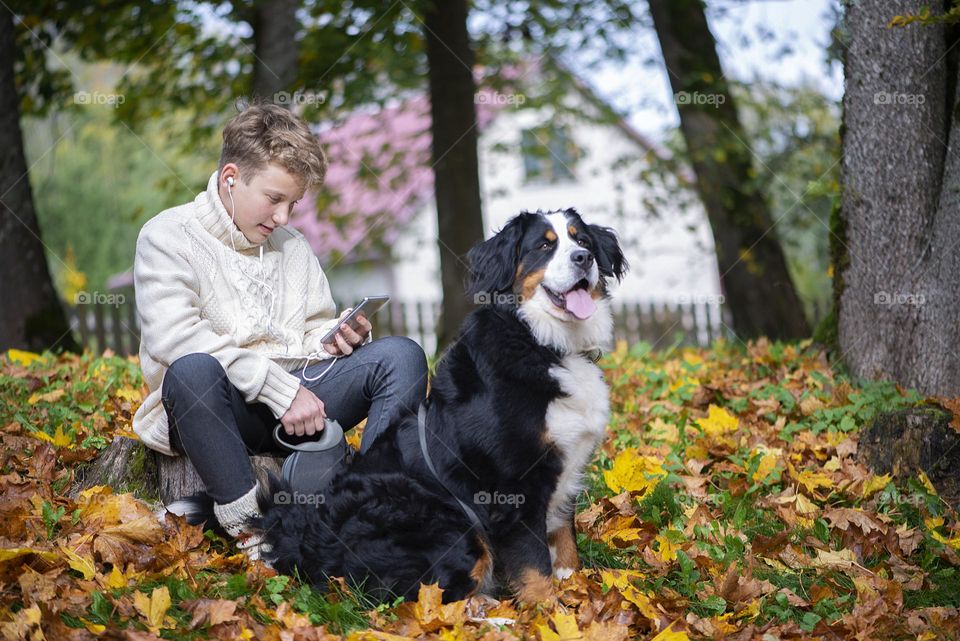 Boy and dog in autumn park
