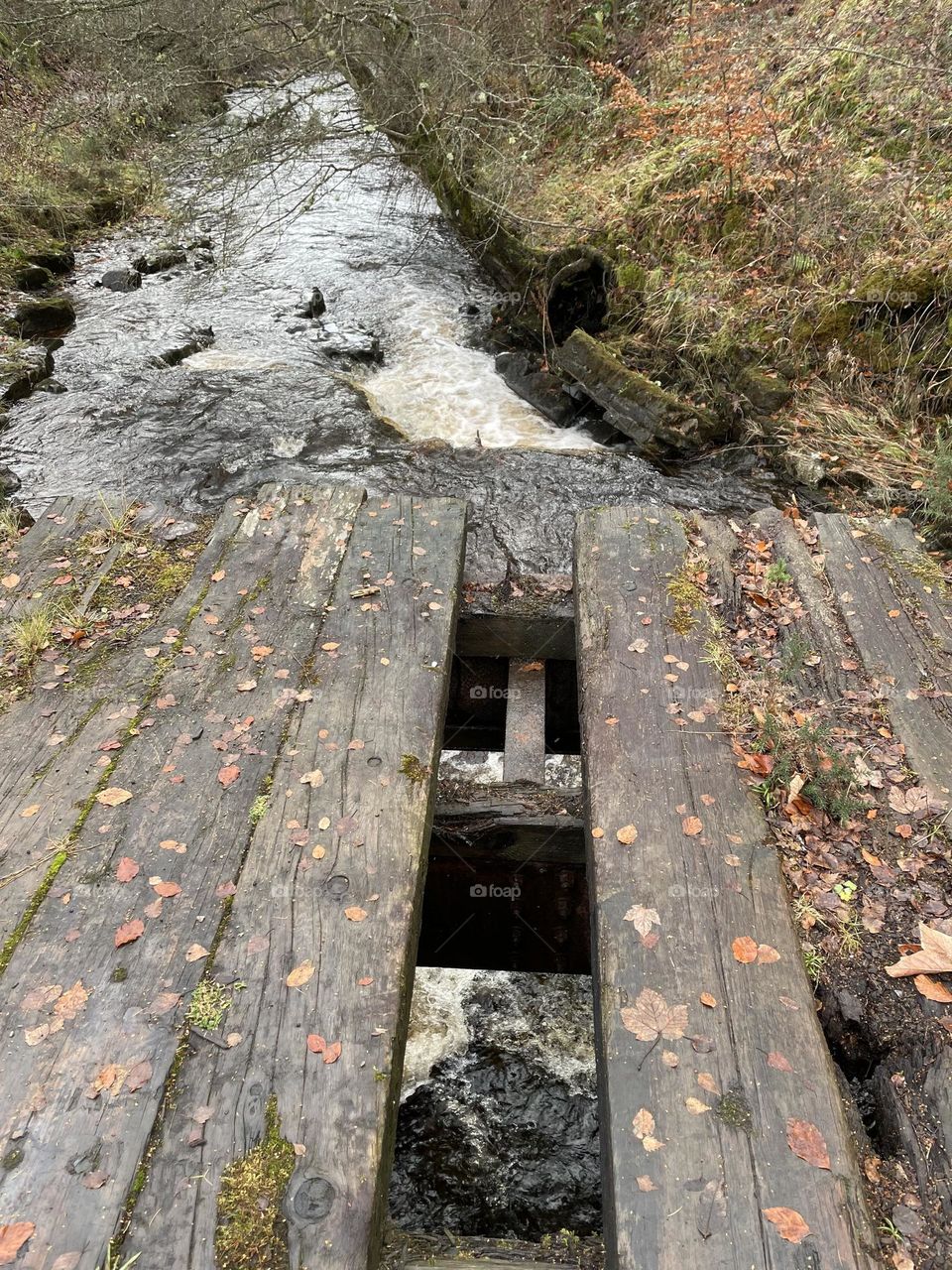 Broken wooden bridge over a river 