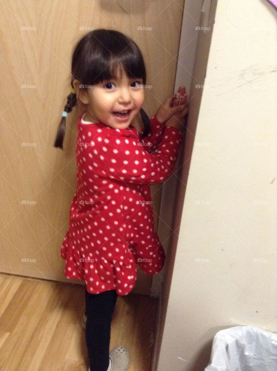 Smiling girl holding door handle