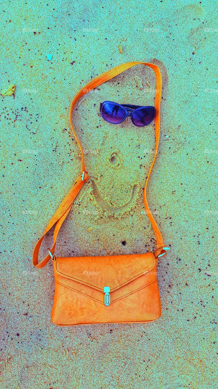 lady bag purse on sea sand with goggles and smile