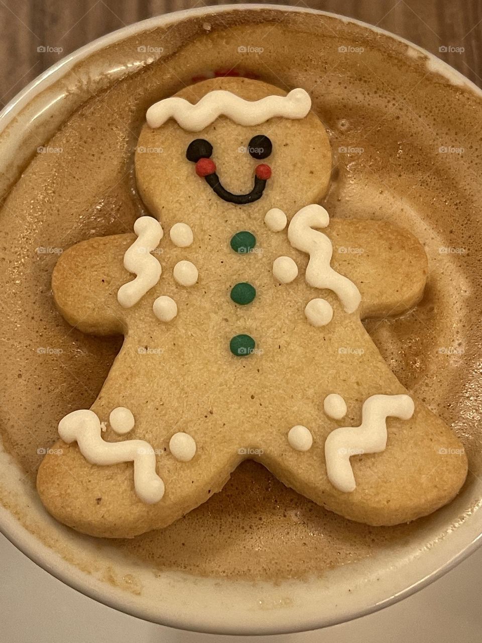 Waiting for Christmas with a sweet gingerbread cookie in a cappuccino