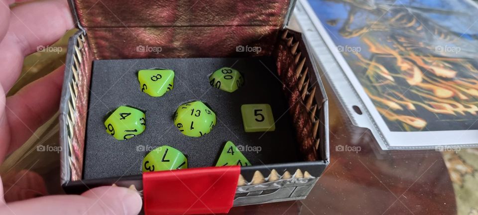 dungeons and dragons dice in a mimic box. triangular sides and triangular teeth