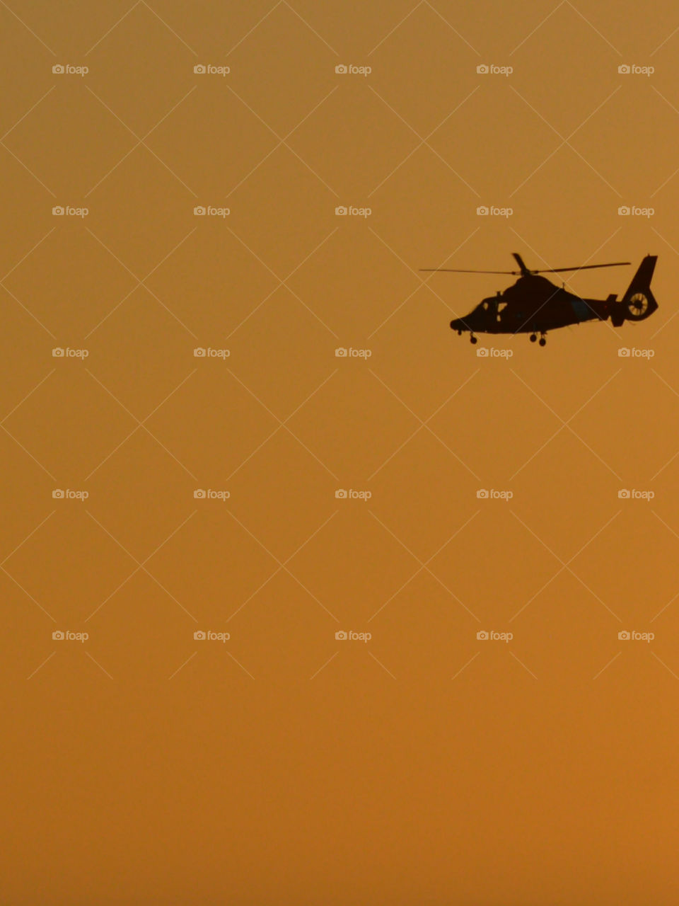 Silhouette of helicopter against sky