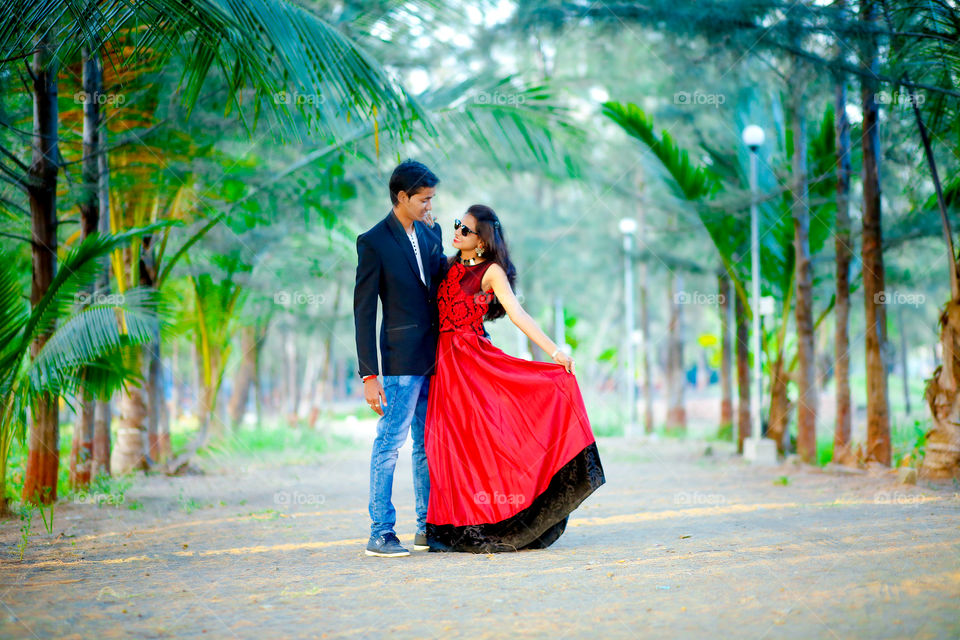 Happy young couple standing in park