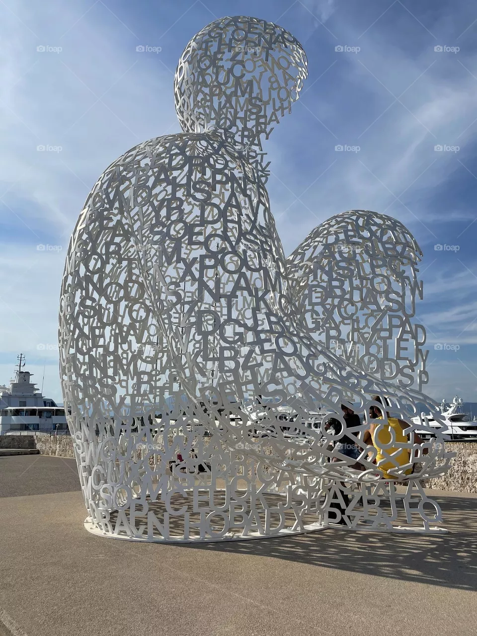 A white sculpture where a man is sitting in Antibes France 