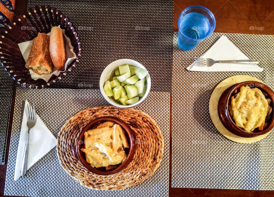 moussaka and bowl with cucumber in pieces