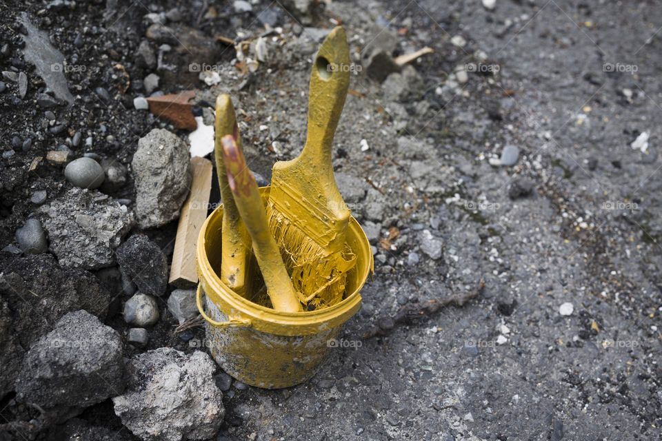 Yellow colored paint brushes in jar