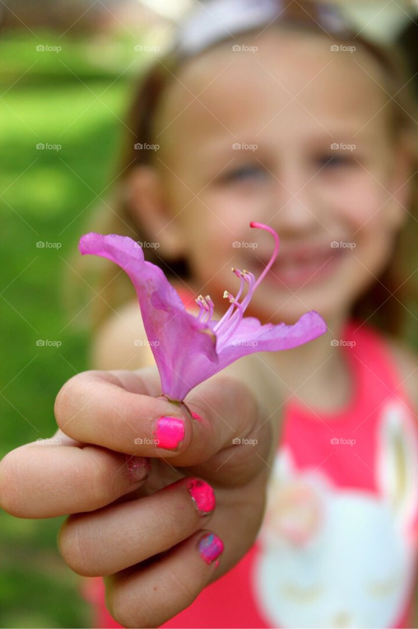 Close-up of girl's hand holding flower