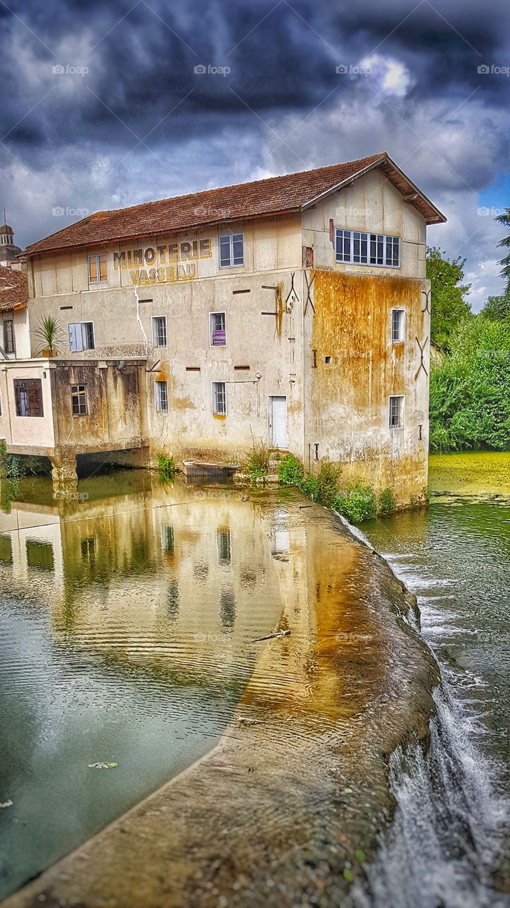 Derelict mill by weir on the River Dropt, France