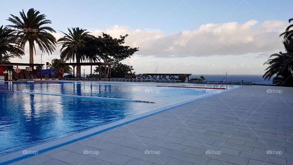 Beautiful empty pool area by the sea in the late afternoon, vacation in Fuerteventura Canary Islands - fint poolområde vid havet på sen eftermiddag, semester 