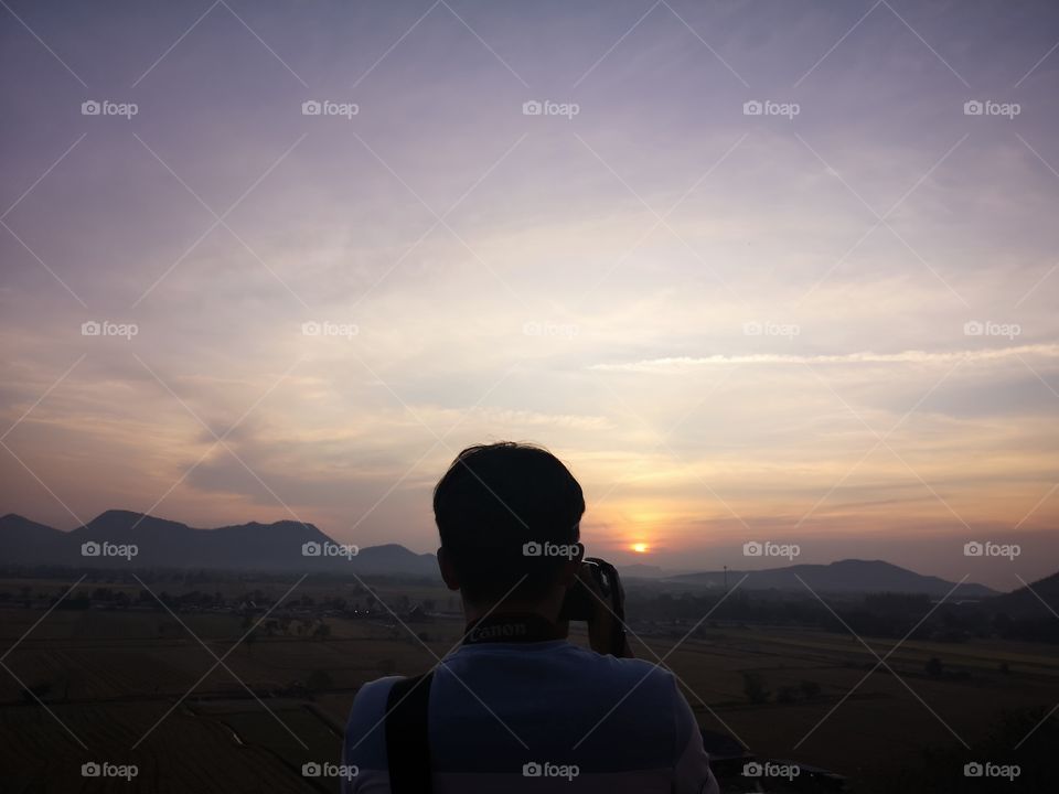 Landscape view of sunrise with photographer.