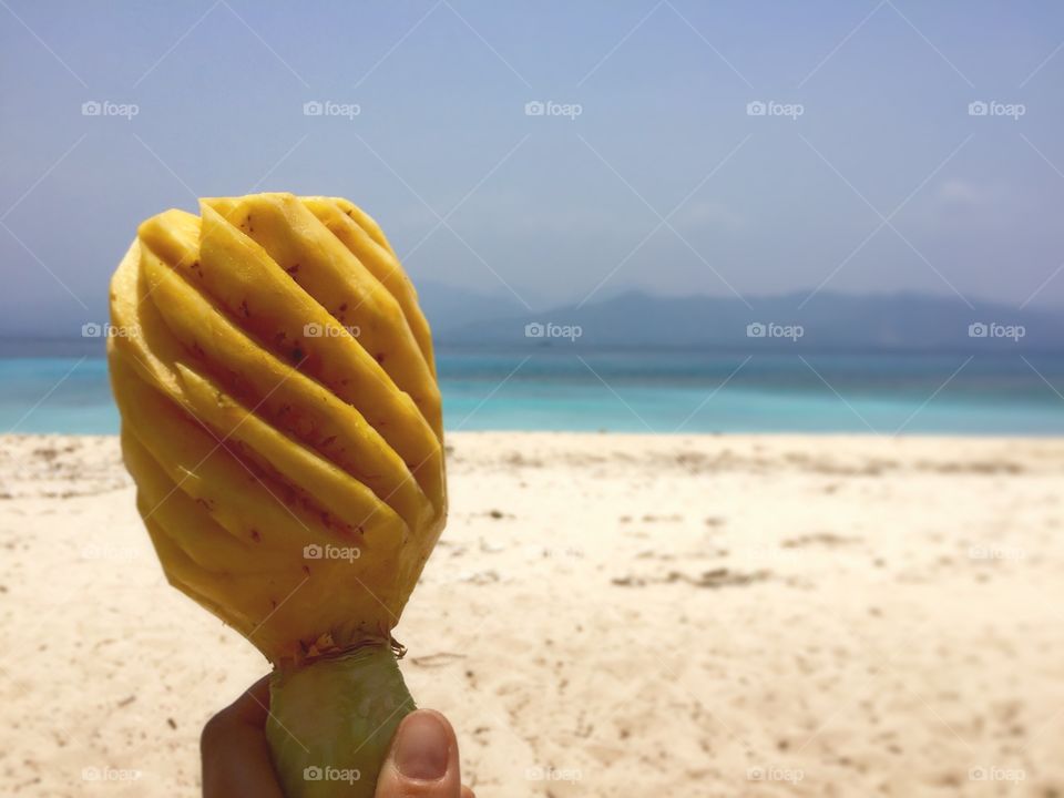 Person holding peeled pinapple